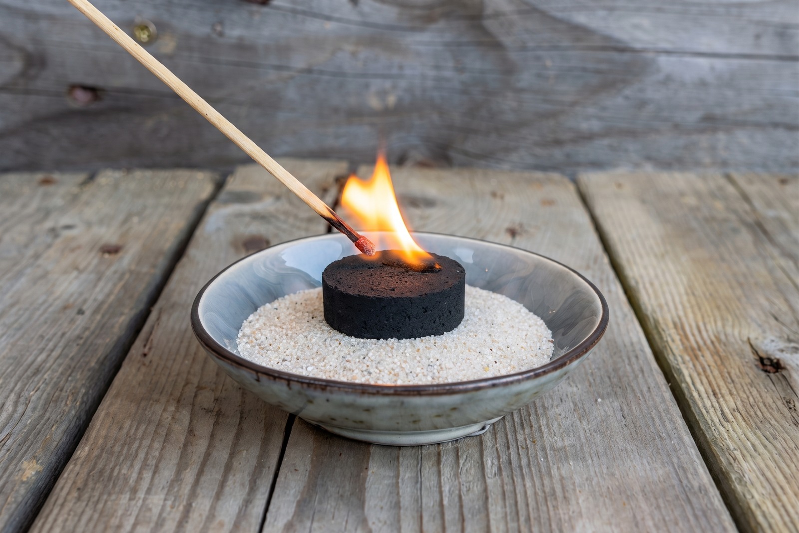 R&auml;ucherkohle wird &uuml;ber der Flamme angez&uuml;ndet, bis das Funkenband durchl&auml;uft